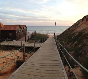 a wooden boardwalk leading to the beach at Lovely Studio Marta on the beach Falesia, Albufeira in Albufeira