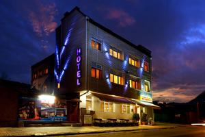 a building with a neon sign on the side of it at Hotel Mehdjarel in Shumen