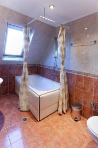 een badkamer met een bad, een douche en een wastafel bij Hotel Mehdjarel in Shumen