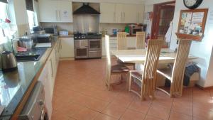 a kitchen with a table and chairs in it at Westmore Bed & Breakfast in Alness