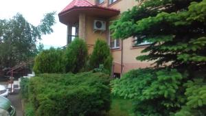 dom z krzakami przed nim w obiekcie Noclegi-Zajazd"Mieszko" w Tarnobrzegu