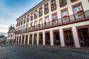 um grande edifício com uma torre de relógio numa rua em Hotel Solar do Rosário em Ouro Preto