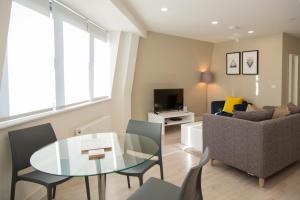 a living room with a glass table and a couch at City Stay Apartments - Platform Bedford in Bedford