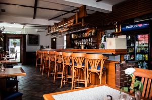 un bar con taburetes de madera en un restaurante en Restaurace A Penzion Garnet, en Olomouc