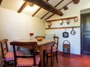 comedor con mesa de madera y sillas en Belvilla by OYO Castagnola en Rocca Grimalda