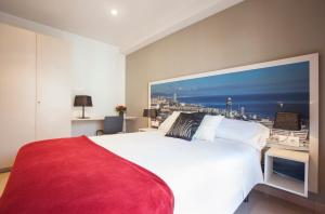 a bedroom with a white bed with a large painting on the wall at Rosselló Apartment in Barcelona