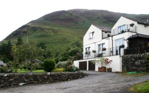 a white house with a hill in the background at StoneyAcre in Keswick