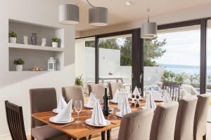 a dining room with a wooden table and chairs at Villa Sima in Makarska