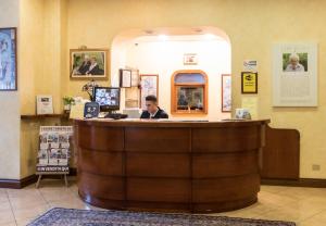 Ein Mann sitzt in einer Bar in einem Restaurant. in der Unterkunft Limone Palace Aparthotel in Limone Piemonte