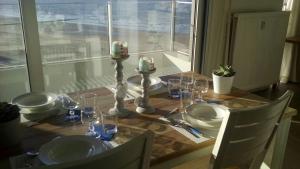 een tafel met borden en glazen op een tafel met een raam bij Apartment Raversijde with Seaview in Oostende