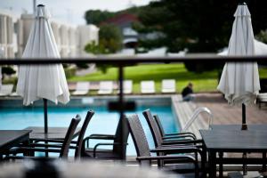 a group of chairs and umbrellas next to a pool at Apple Hotel & Konferens Göteborg in Gothenburg