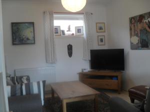 エディンバラにあるEdinburgh Duplex Apartmentのリビングルーム(テレビ、テーブル付)