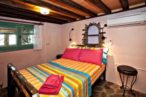 a bedroom with a colorful bed in a room at Tinos Habitart in Triandáros +57 photos