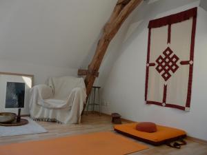 Cette chambre mansardée comprend une chaise et un tapis. dans l'établissement l'atelier expo du Grand Island, à Grand Island