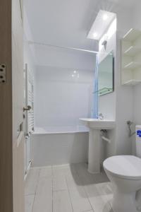 a white bathroom with a toilet and a sink at Summer Fun in Constanţa