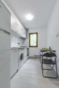 a white kitchen with a washing machine and a table at Summer Fun in Constanţa
