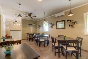 a dining room with tables and chairs and a ceiling fan at Hotel Sansegus in Susak