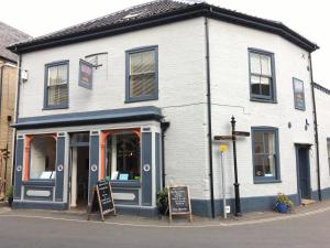 un edificio blanco con un cartel delante en Bang in Wells en Wells next the Sea