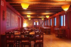 a restaurant with wooden tables and chairs and lights at Village Vacances Le Grépillon in Les Rousses