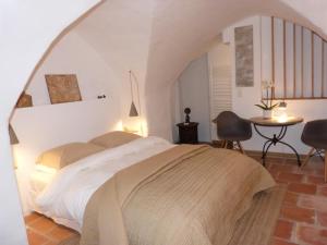 a bedroom with a bed and a table and chairs at le tilleul in Villevieille