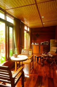 uma sala de estar com mesa e cadeiras e uma cozinha em Ruenkanok Thaihouse Resort em Hua Hin