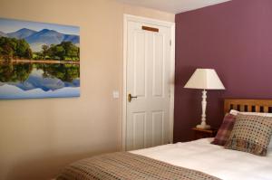 Un dormitorio con una cama y un cuadro en la pared. en StoneyGill, en Keswick