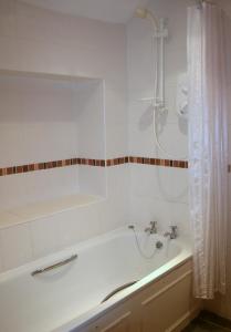 Un baño blanco con bañera y ducha. en StoneyGill, en Keswick