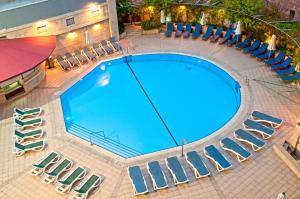 Elle offre une vue sur la grande piscine bordée de chaises. dans l'établissement Leonardo Hotel Jerusalem, à Jérusalem