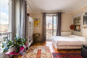 ein Schlafzimmer mit einem Bett und einem Balkon in der Unterkunft Veeve - Overlooking the Seine on Ile de la Cité in Paris