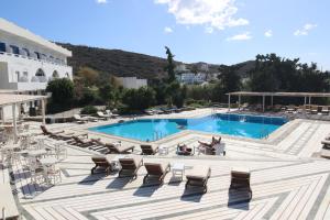 een zwembad met ligstoelen en een resort bij Armadoros Hotel / Ios Backpackers in Ios Chora