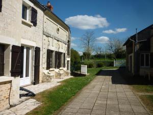 an old stone building with a sidewalk next to it at Gite Maison de campagne 86120-22 couchages in Montbrillais