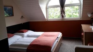 ペーチにあるBerg Toboz Panzióのベッドルーム1室(ベッド2台、窓付)