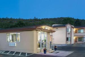 a building in a parking lot with a mountain in the background at Travelodge by Wyndham Williams Grand Canyon in Williams