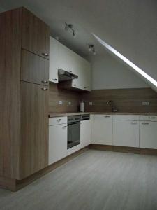 a large kitchen with white cabinets and a sink at Ferienwohnung Reuter Christine in Bad Staffelstein