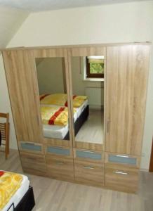 ein großer Holzschrank mit einem Bett in einem Zimmer in der Unterkunft Ferienwohnung Reuter Christine in Bad Staffelstein