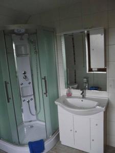 ein Badezimmer mit einem Waschbecken und einer Dusche neben einem Waschbecken in der Unterkunft Ferienwohnung Reuter Christine in Bad Staffelstein