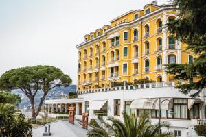 a large yellow building with a walkway in front of it at Eden by PortofinoHomes in Santa Margherita Ligure