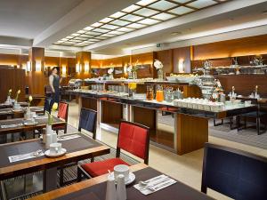 a restaurant with tables and chairs and a person in the background at K+K Hotel Fenix in Prague