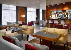 a restaurant with couches and tables and a bar at K+K Hotel Fenix in Prague