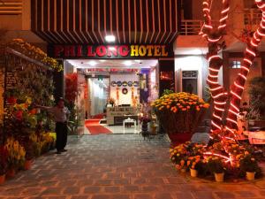 a man standing in front of a store with flowers at Phi Long Hotel in Tuy Hoa