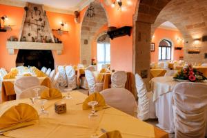 un salón de banquetes con mesas blancas y sillas blancas en Hotel Salento, en Specchia