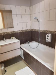 a bathroom with a bath tub and a sink at LOGIS - Château de la Motte - Hôtel & Restaurant in Liessies +31 photos