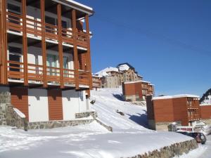 ein Gebäude im Schnee neben einigen Gebäuden in der Unterkunft T2 confort,Vue d'Exception,calme,prés des pistes in La Mongie