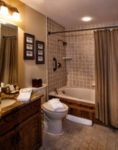 a bathroom with a toilet and a tub and a sink at Bob Timberlake Inn at Chetola Resort in Blowing Rock