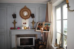 sala de estar con TV y chimenea en Maison de village sur la route du cidre, en Cambremer