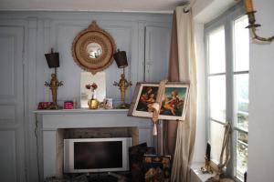 a living room with a television and a fireplace at Maison de village sur la route du cidre in Cambremer