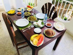 a wooden table with plates of food on it at Pearl House Resort in Anuradhapura