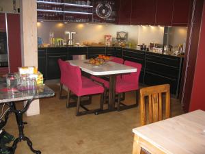 Casa il Siemi في Luven: مطبخ مع طاولة وكراسي وردية