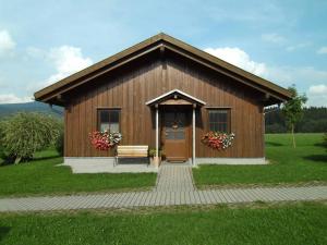 a small wooden building with a bench in a field at Ferienhaus Zinnöcker in Breitenberg