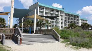 a hotel building with stairs in front of it at Bermuda Sands On The Boardwalk in Myrtle Beach